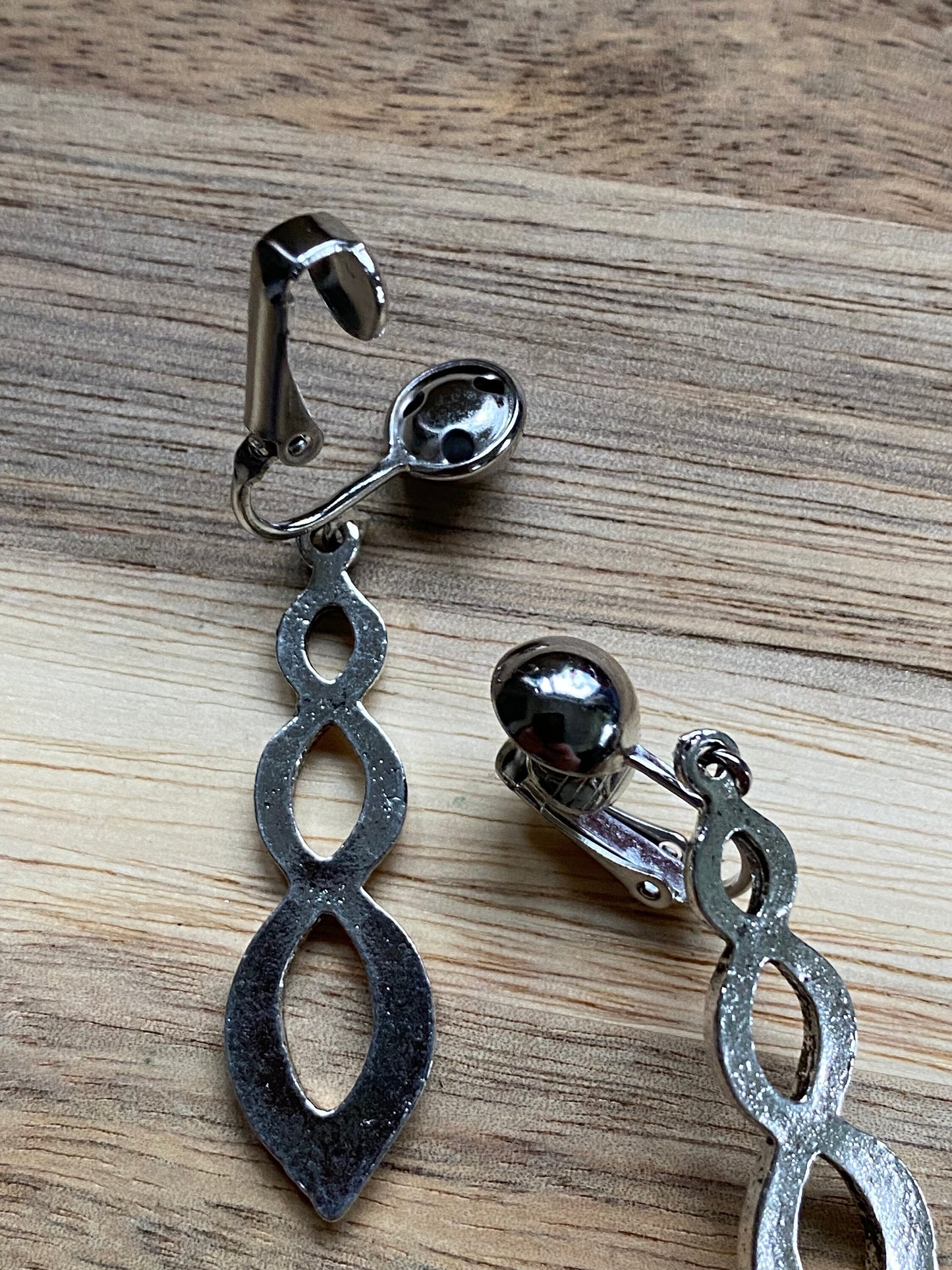 Dangling clip on silver infinity earrings