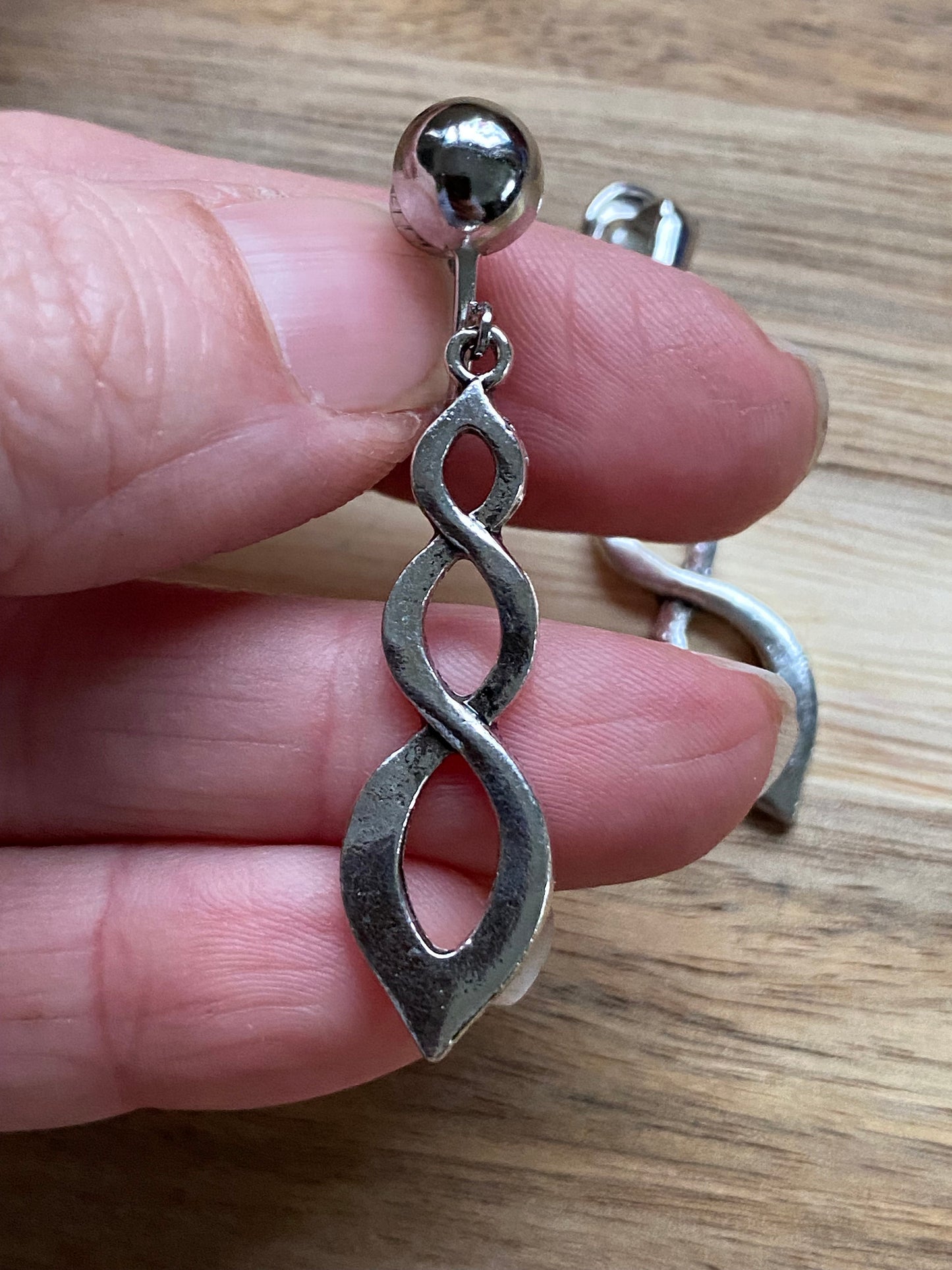 Dangling clip on silver infinity earrings