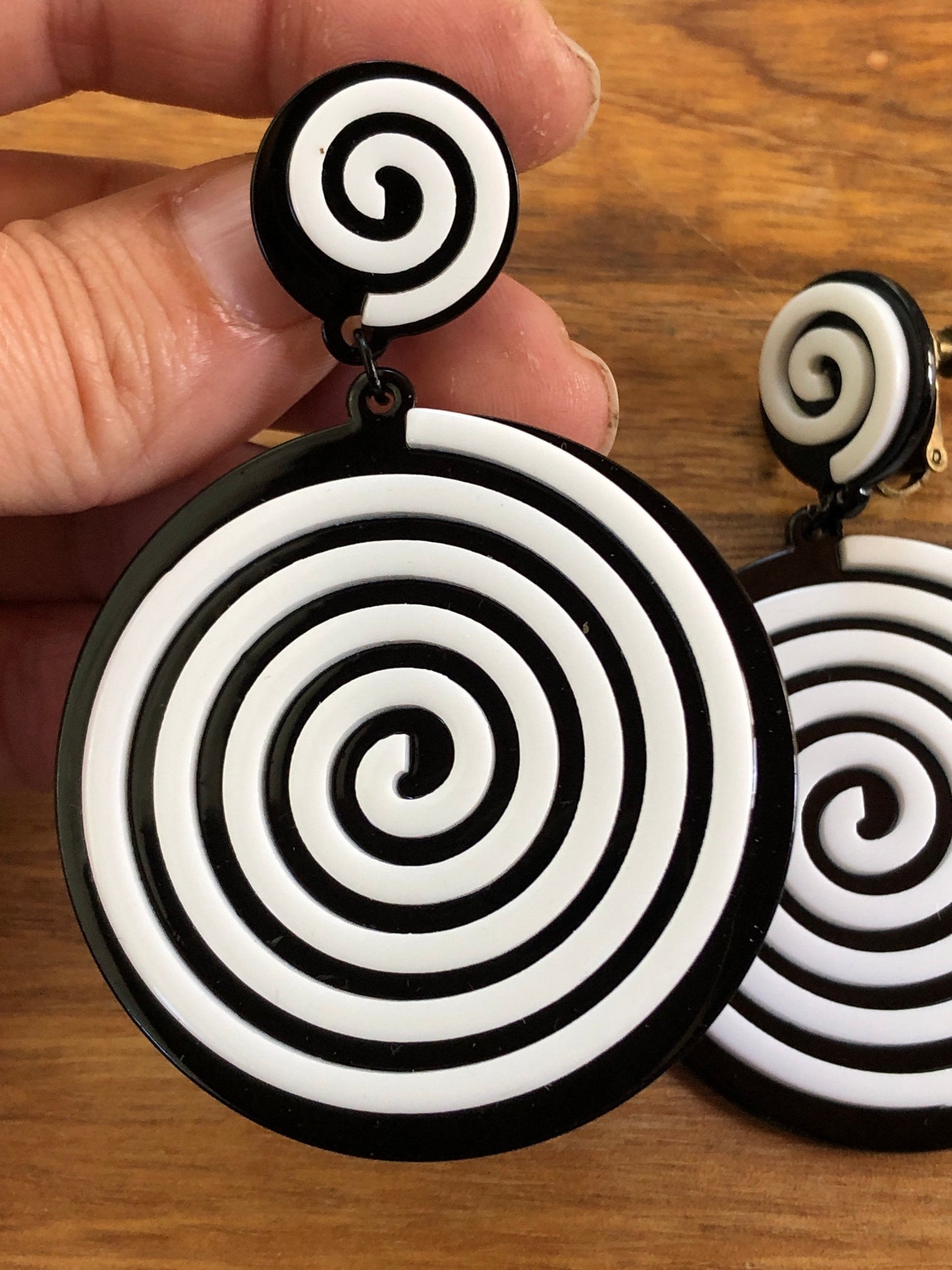 Oversized dangling black and white plastic swirl clip on earrings