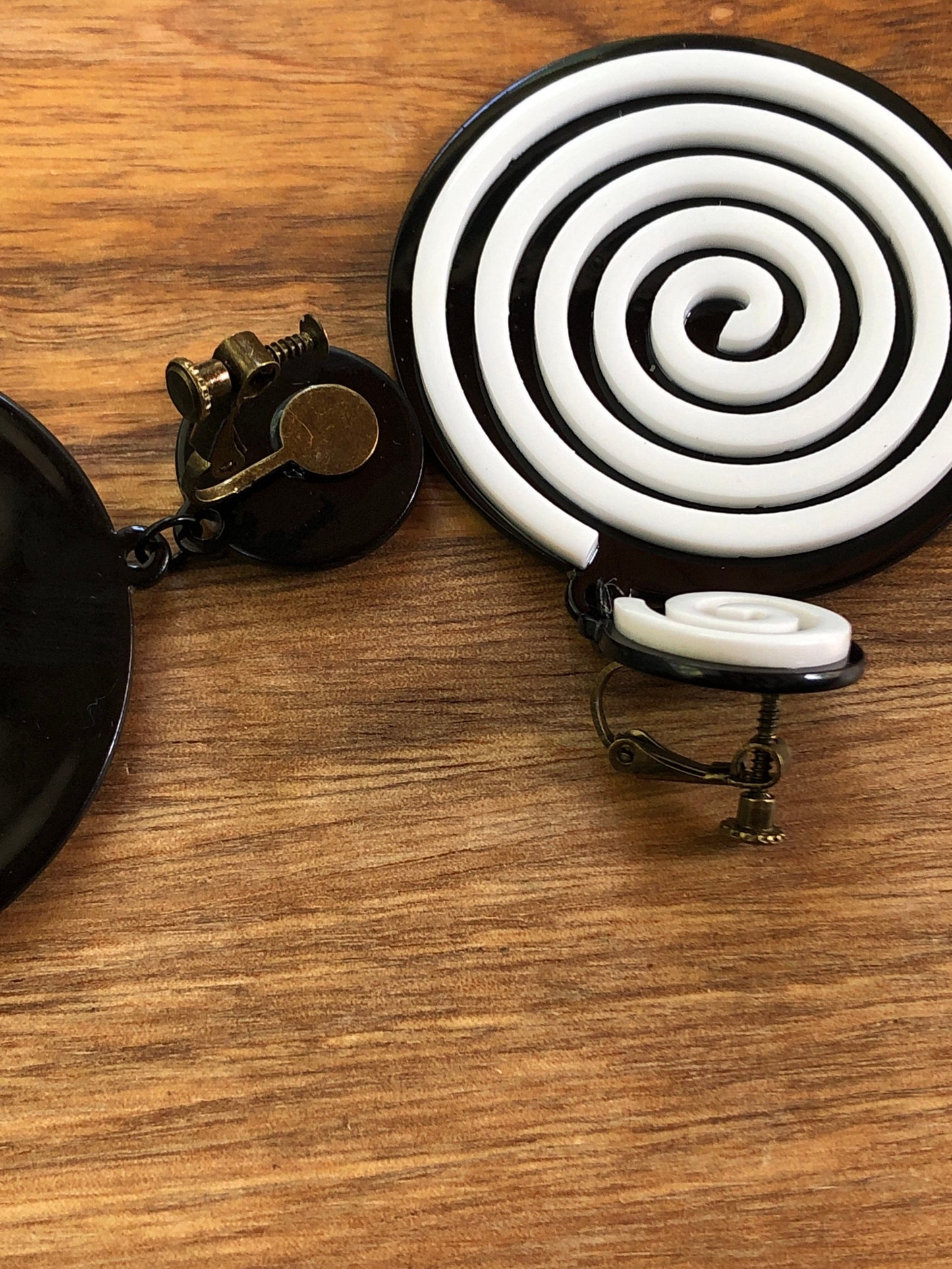 Oversized dangling black and white plastic swirl clip on earrings