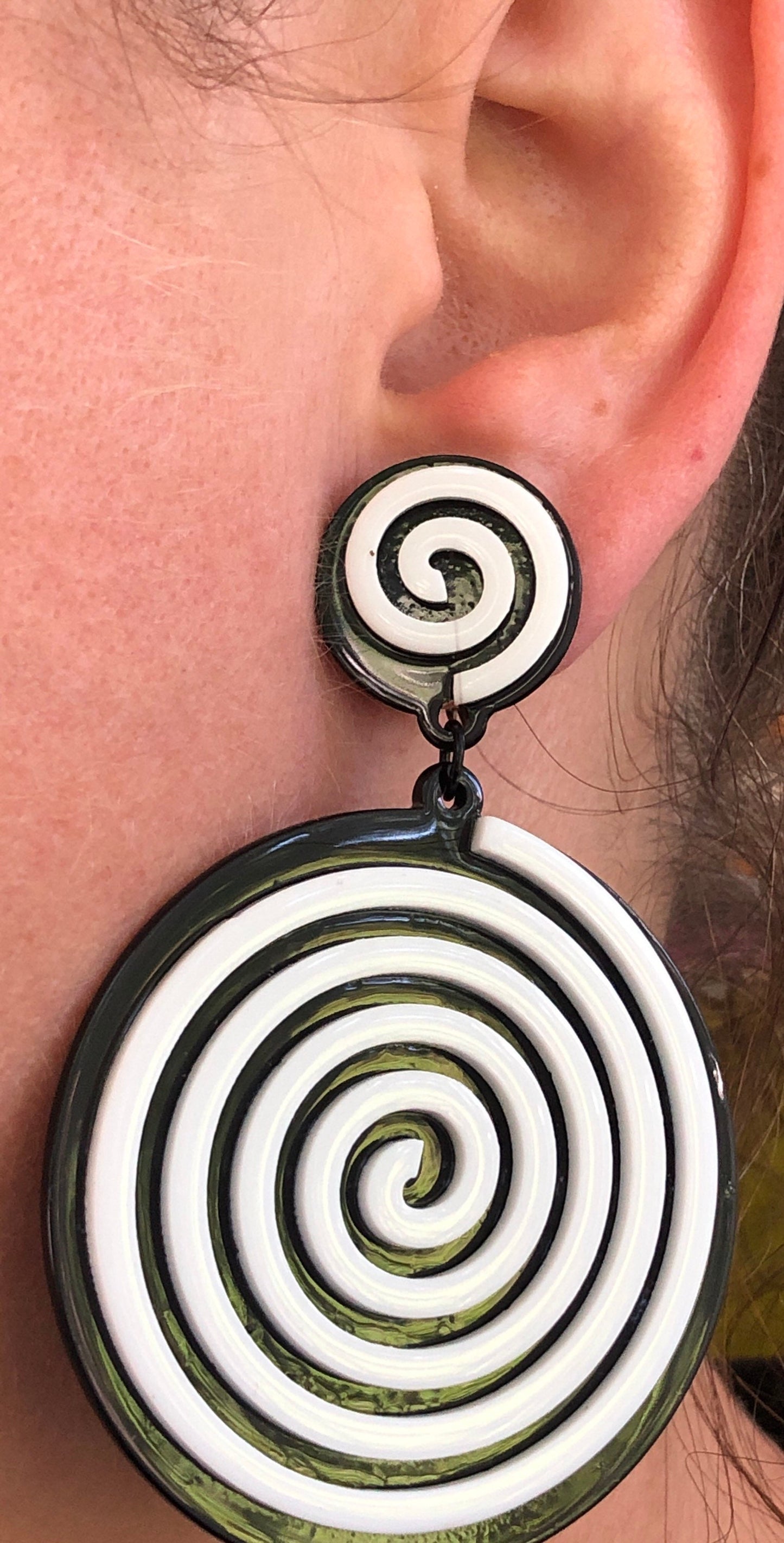 Oversized dangling black and white plastic swirl clip on earrings