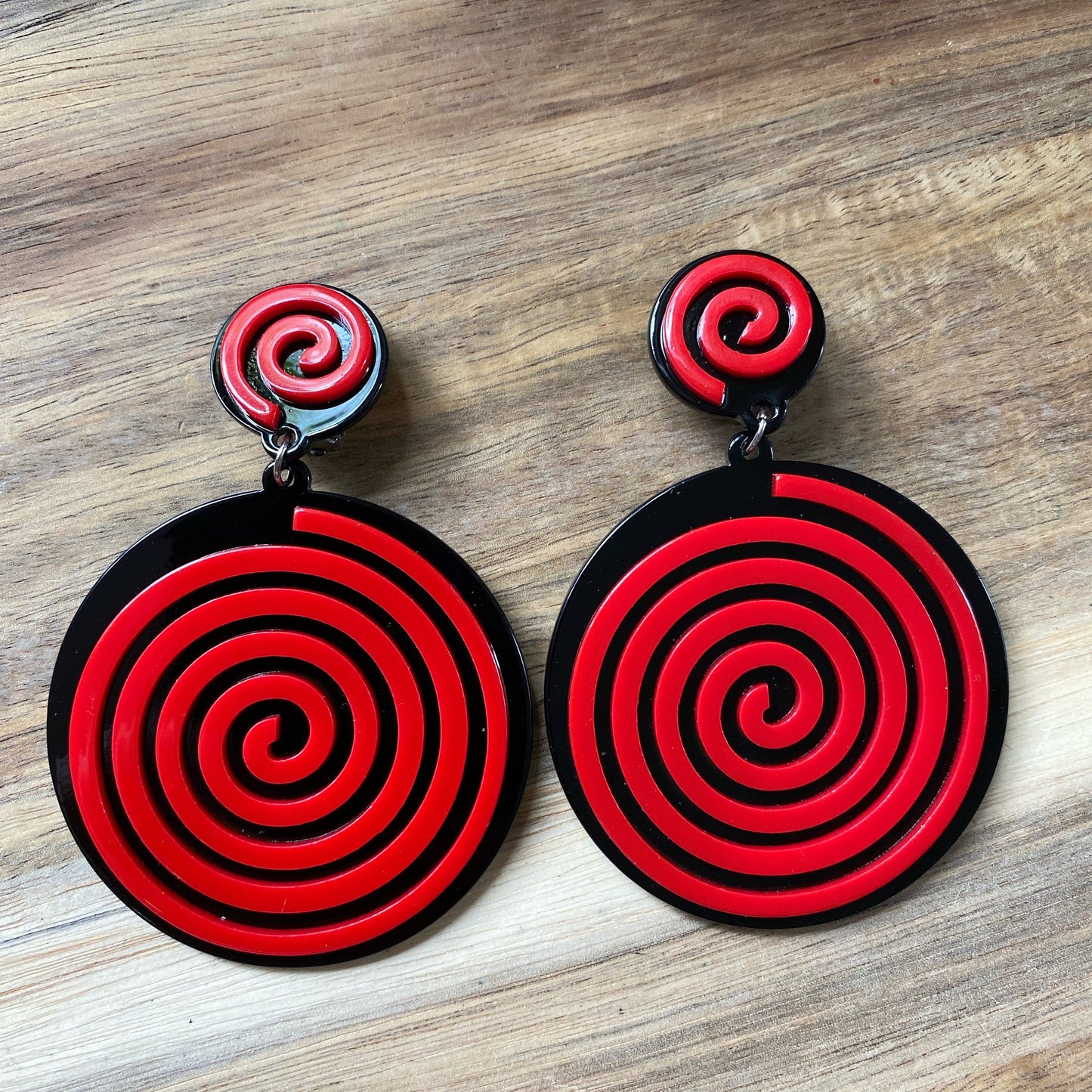 Oversized dangling black and white plastic swirl clip on earrings