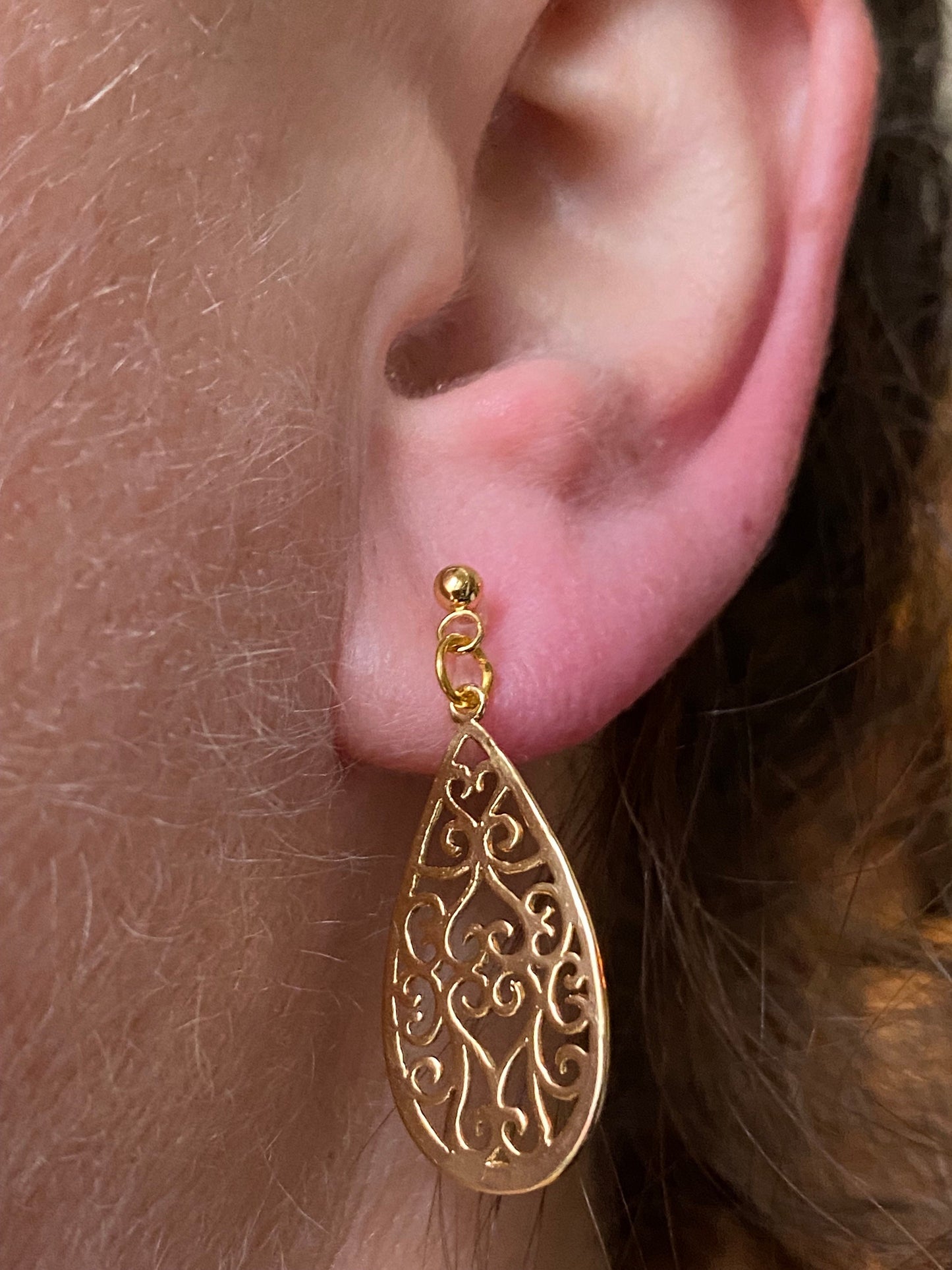 Dangling invisible clip on earrings with gold coloured teardrop pendants