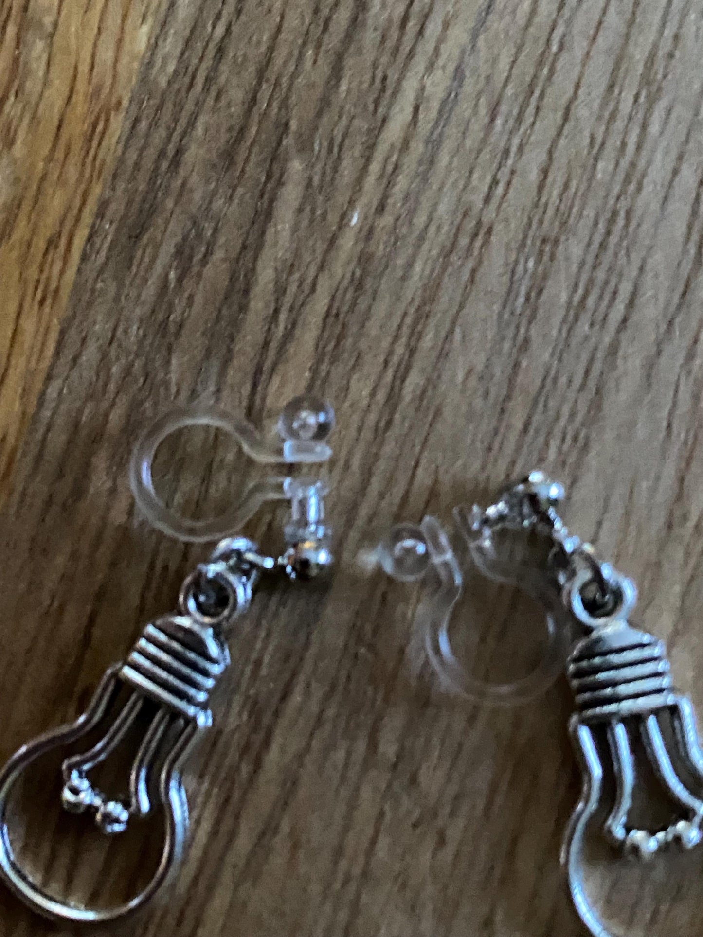 Dangling invisible clip on earrings with silver coloured lightbulb pendants