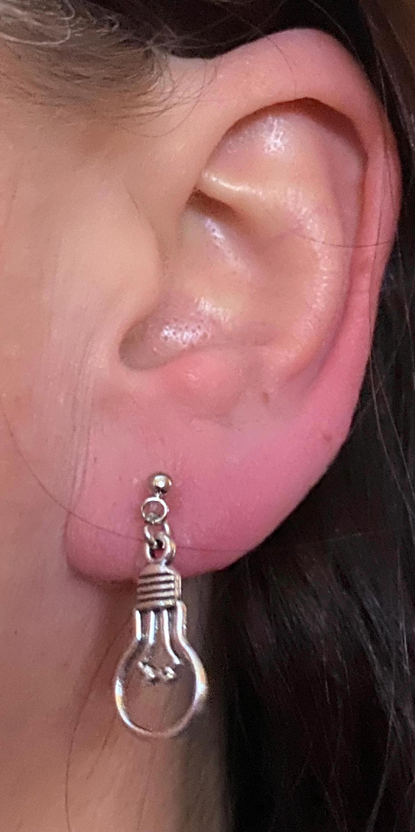 Dangling invisible clip on earrings with silver coloured lightbulb pendants