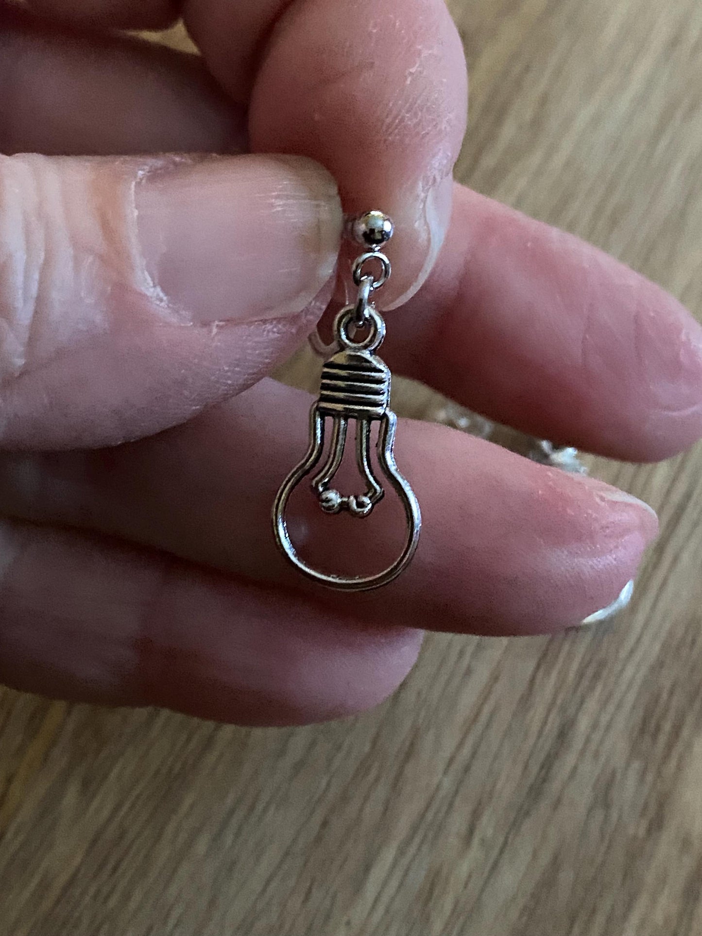 Dangling invisible clip on earrings with silver coloured lightbulb pendants