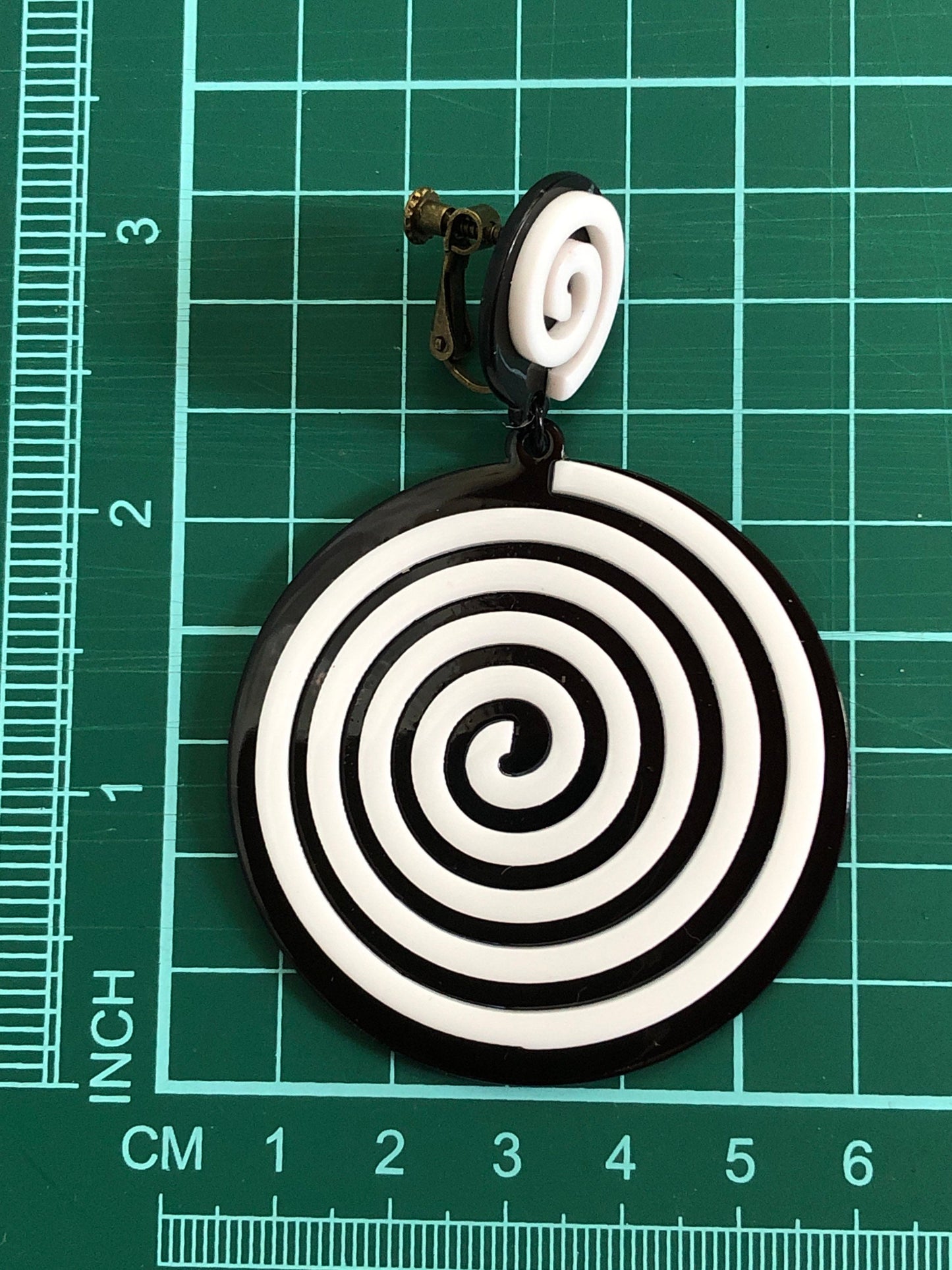 Oversized dangling black and white plastic swirl clip on earrings