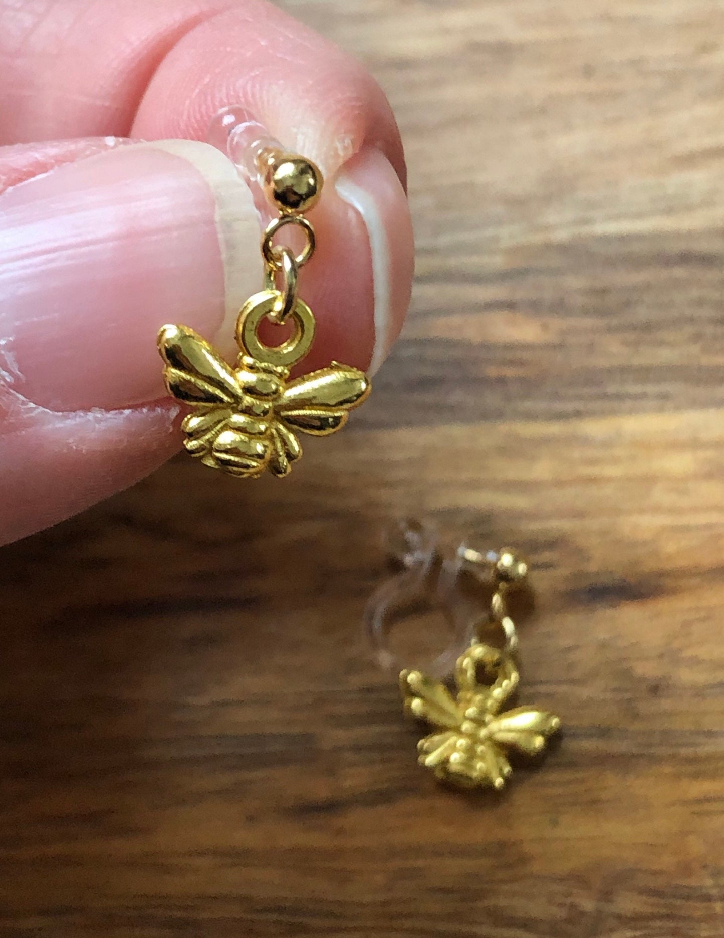 Dangling invisible clip on earrings (no piercing no pierce) with tiny golden bumblebee pendants