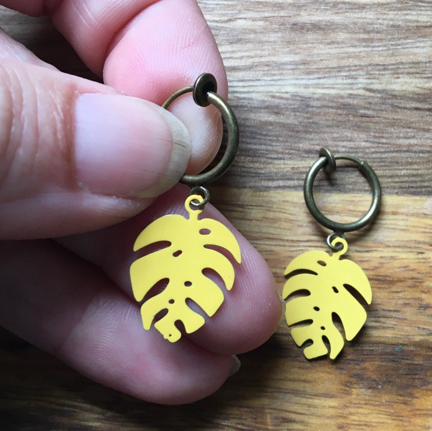 Tiny enamel monstera leaves on bronze spring hoop clip on earrings (no piercing)